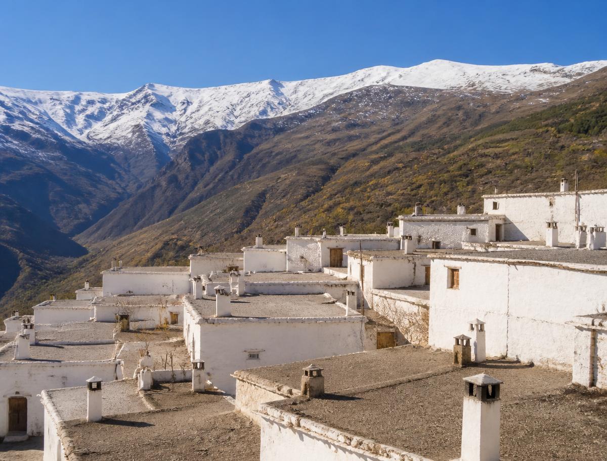 Pueblo blanco de la Alpujarra con Sierra Nevada nevada al fondo